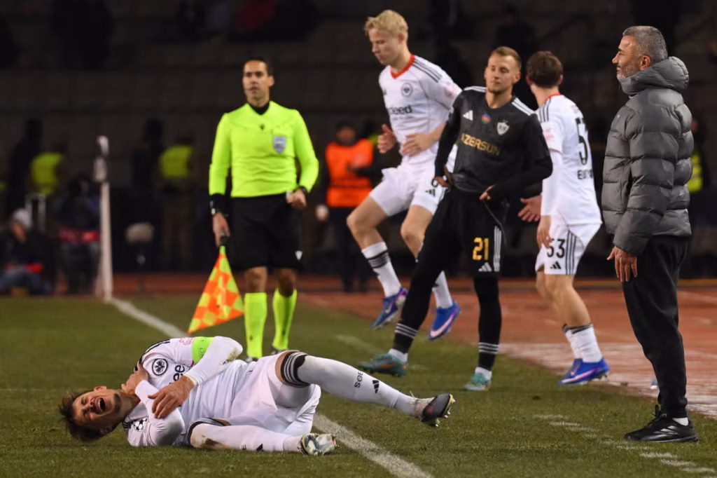 Qurban Qurbanov Çempionlar Liqasında "Ayntraxt"ın futbolçusu Robin Koxun meydanda ağrı içində necə yuvarlandığını izləyir. Fotoqraf: Tofik Babayev/AFP/Getty Images